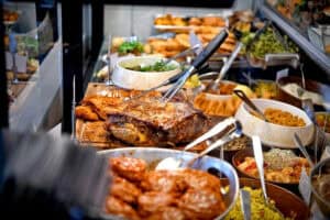 מזנון עם מגוון מנות, כולל בשר צלוי, ירקות, סלטים ותוספות.